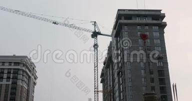 施工现场的高吊车工程.. 摩天大楼与起重机。 在施工现场工作的工人.. 建筑工人造房子。 你好